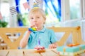 Cute little boy having fun and celebrate birthday party with colorful decoration and cake Royalty Free Stock Photo