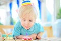 Cute little boy having fun and celebrate birthday party with colorful decoration and cake Royalty Free Stock Photo