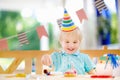 Cute little boy having fun and celebrate birthday party with colorful decoration and cake Royalty Free Stock Photo