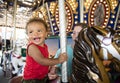Cute little boy having fun riding on a colorful carnival carousel