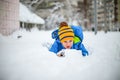 Cute little boy having fun with snow in winter park. Happy child playing with snow in winter park Royalty Free Stock Photo