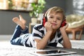 Cute little boy with headphones and tablet listening to audiobook