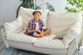 Cute little boy with headphones and tablet listening to audiobook at home Royalty Free Stock Photo