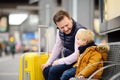 Little boy and his father waiting express train on railway station platform or waiting their flight at the airport Royalty Free Stock Photo