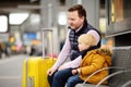 Little boy and his father waiting express train on railway station platform or waiting their flight at the airport Royalty Free Stock Photo