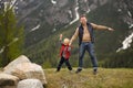 Cute little boy and his father walks in Swiss national Park on spring. Hiking with little kids. Dangerous situation: standing on Royalty Free Stock Photo