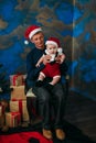 Cute little boy and his grandpa sitting at Christmas tree