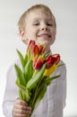 Cute little boy holding a bouquet of flowers. Tulips. Mothers Day. International Women`s Day. Portrait of a happy little Royalty Free Stock Photo