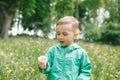 Cute little boy holding dandelion on meadow Royalty Free Stock Photo