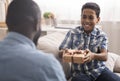 Cute little boy holding gift for father behind his back, closeup Royalty Free Stock Photo