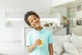 Cute little boy holding glass of orange juice and drinking at home Royalty Free Stock Photo