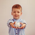 Cute little boy holding a piggy bank, soft focus on money box Royalty Free Stock Photo