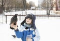 cute little boy holds a wild pigeon on his hand on a winter day Royalty Free Stock Photo