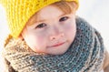 Cute little boy kid in winter clothes walking under snow. Child in blue jacket and yellow hat walks in snow-covered Royalty Free Stock Photo