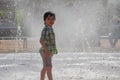 Cute little boy is laughing and having fun running under a water fountain Royalty Free Stock Photo