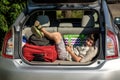 Cute little boy laying on the back of the bags and baggage in the car trunk ready to go on vacation with happy Royalty Free Stock Photo