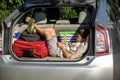 Cute little boy laying on the back of the bags and baggage in the car trunk ready to go on vacation with happy Royalty Free Stock Photo