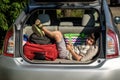 Cute little boy laying on the back of the bags and baggage in the car trunk ready to go on vacation with happy expression. Kid Royalty Free Stock Photo