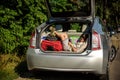 Cute little boy laying on the back of the bags and baggage in the car trunk ready to go on vacation with happy expression. Kid Royalty Free Stock Photo