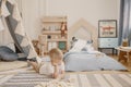 Cute little boy laying on the floor of his stylish scandinavian bedroom, real photo