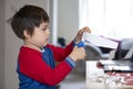 Cute little boy learning how to use the scissors cut the paper, Schoolboy using scissors cutting white paper, Children learn and p