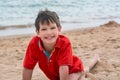 Cute little boy lies on the sand on the seashore happy, Royalty Free Stock Photo