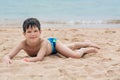 Cute little boy lies on the sand on the seashore happy, Royalty Free Stock Photo