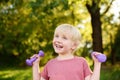 Cute little boy lifting dumbbells outdoors Royalty Free Stock Photo