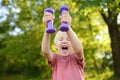 Cute little boy lifting dumbbells outdoors Royalty Free Stock Photo