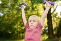 Cute little boy lifting dumbbells outdoors Royalty Free Stock Photo