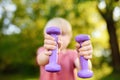 Cute little boy lifting dumbbells outdoors Royalty Free Stock Photo