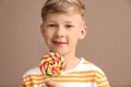 Cute little boy with lollipop on color background Royalty Free Stock Photo