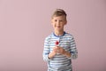 Cute little boy with lollipop on color background Royalty Free Stock Photo