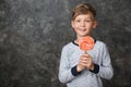 Cute little boy with lollipop on grey background Royalty Free Stock Photo