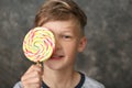 Cute little boy with lollipop on grey background Royalty Free Stock Photo