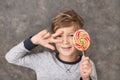 Cute little boy with lollipop on grey background Royalty Free Stock Photo