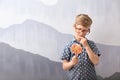 Cute little boy with lollipop near grey wall Royalty Free Stock Photo