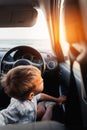 Cute little boy looking out of window of a car during sunset on the beach Royalty Free Stock Photo