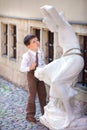 Cute little boy looking at white statue