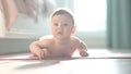 Cute little boy lying on his forearms on the floor.