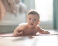 Cute little boy lying on his forearms on the floor.