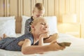 Little brother and sister lying in bed watching videos together Royalty Free Stock Photo