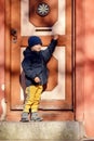 A cute little boy next to a big beautiful vintage door during a fall walk in the old town Royalty Free Stock Photo