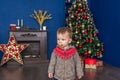 Cute little boy with a pacifier is standing near christmas tree at home Royalty Free Stock Photo