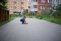 Cute little boy picks up a road of their forgotten Teddy bear, stylish jeans with suspenders and plaid shirt . Memories