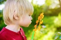 Cute little boy is playing with big bubbles outdoor. Child is blowing big and small bubbles simultaneously Royalty Free Stock Photo