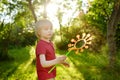 Cute Little Boy Is Playing With Big Soap Bubbles Outdoor. Child Is Blowing Big And Small Bubbles Simultaneously. Summer Leisure