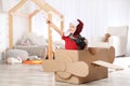 Cute little boy playing with binoculars and cardboard airplane Royalty Free Stock Photo