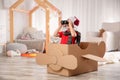 Cute little boy playing with binoculars and cardboard airplane Royalty Free Stock Photo