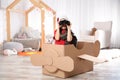 Cute little boy playing with binoculars and cardboard airplane Royalty Free Stock Photo